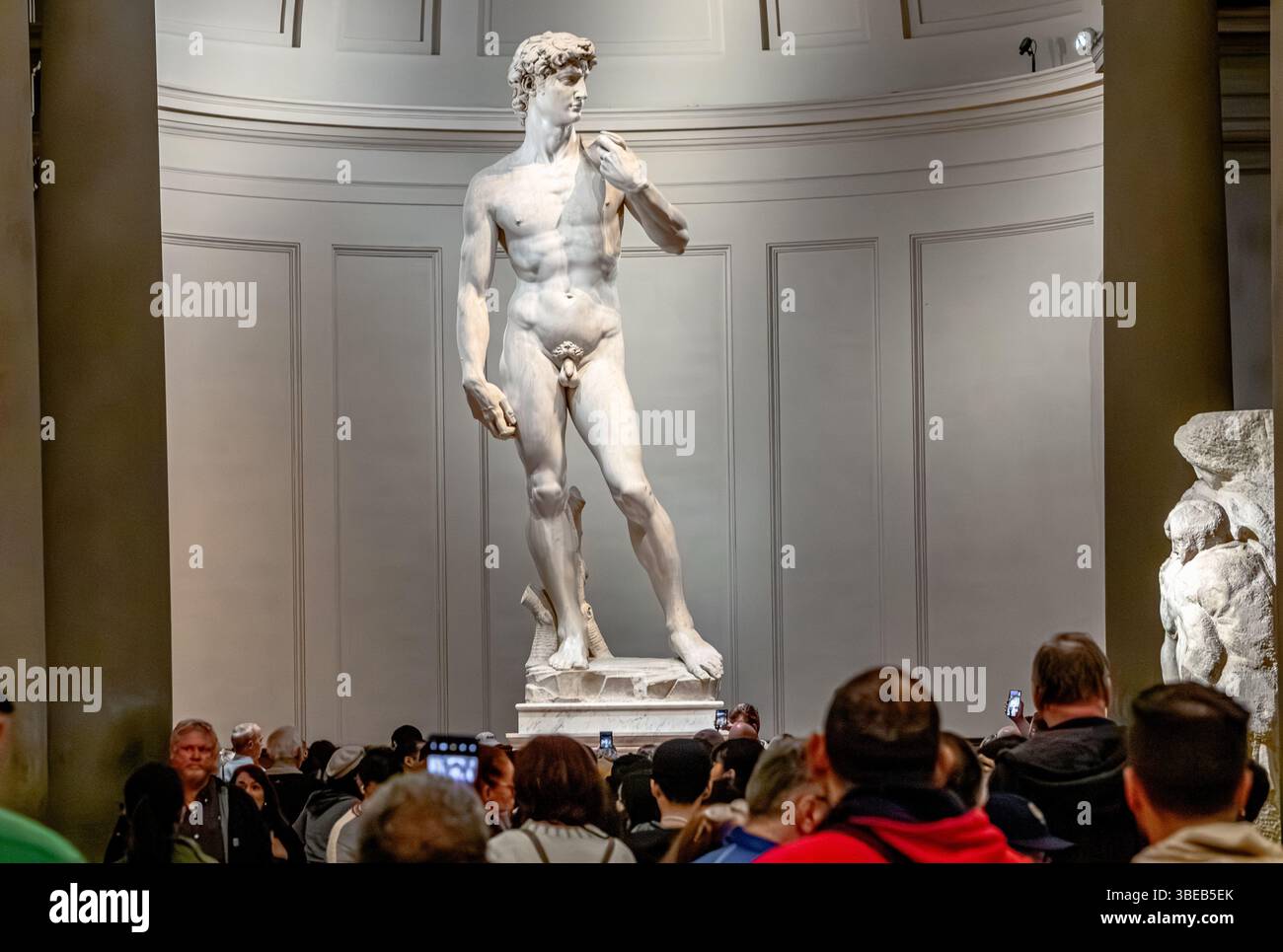 Menschenmassen schauen Michelangelos David, eine Skulptur aus Marmor, die in der Galleria dell’Accademia di Firenze, Florenz, Italien, ausgestellt ist Stockfoto