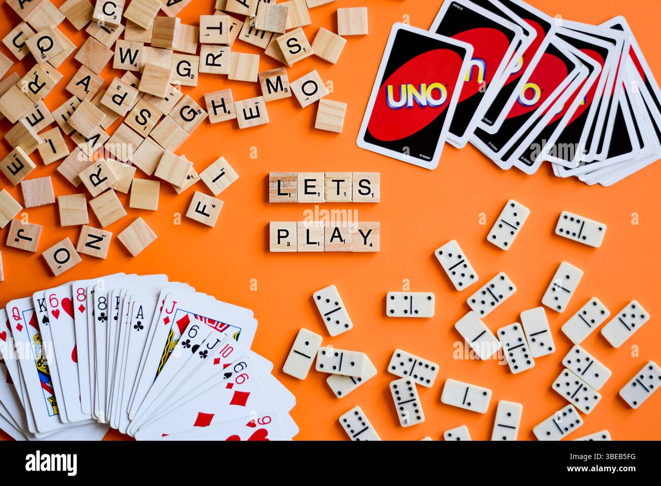 Brettspiele auf orangefarbenem Hintergrund mit Worten Let's Play Stockfoto