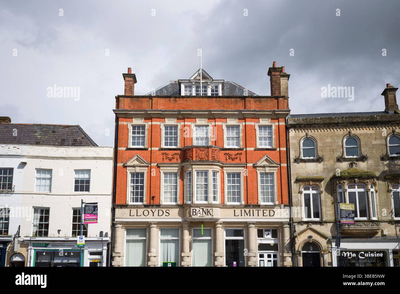 Market Place, Devizes, ein spätviktorianisches Geschäftsgebäude aus Backstein, Terrakotta und Stein aus dem Jahr 1892, heute Lloyds Bank, und benachbarte Gebäude, bewölkter Himmel. Stockfoto