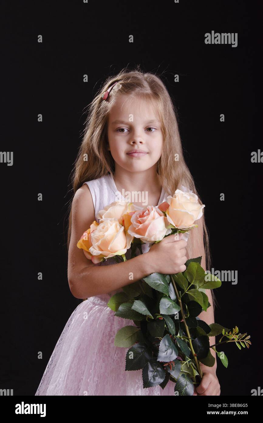 Porträt eines fünfjährigen Mädchens mit einem Strauß Blumen auf schwarzem Hintergrund Stockfoto