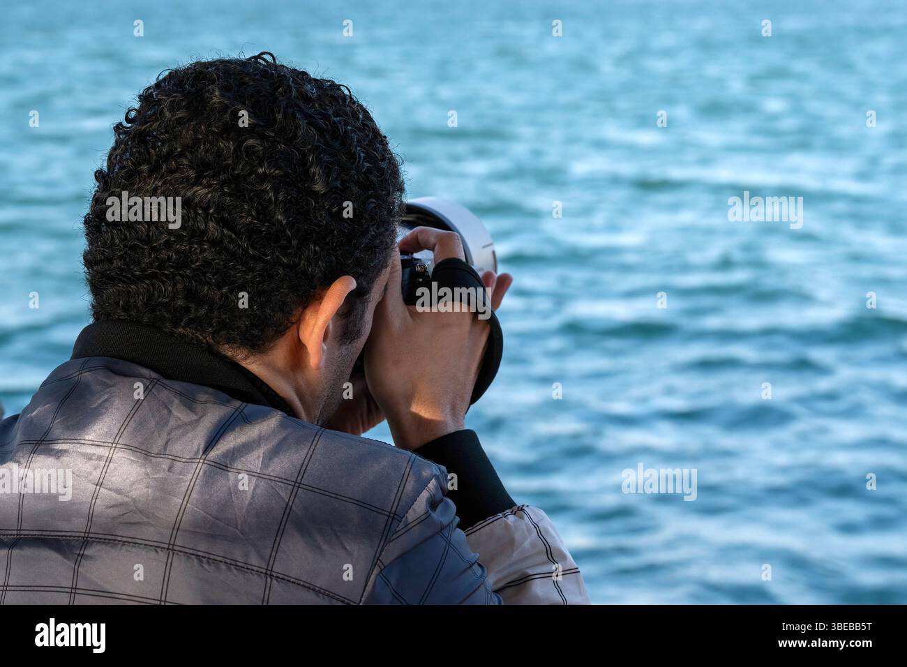Der Mann macht Fotos mit der Kamera, die an der Hand hält. Reisende und Touristen Stockfoto