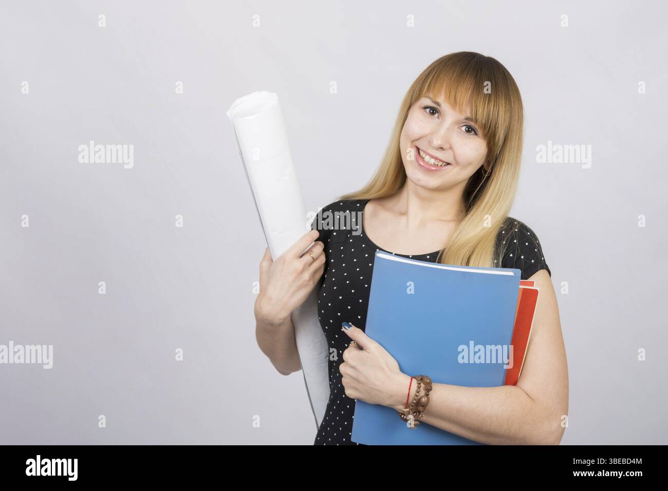 Studentin, lächelnd und Blaupausen und einen Ordner mit Dokumenten Stockfoto