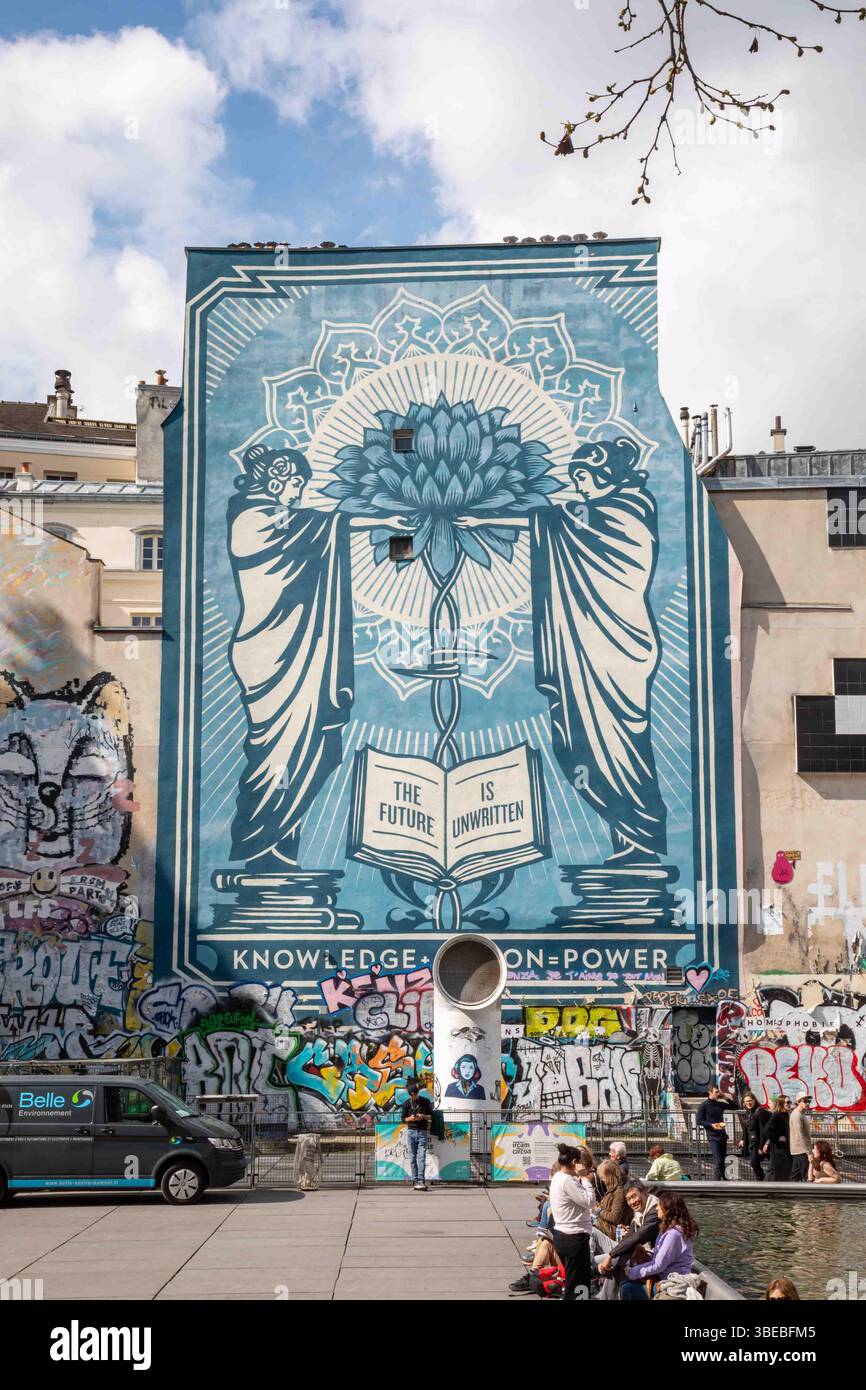 Wissen + Handeln = Macht. Großes Graffiti von Shepard Fairey am Place Igor Strawinsky im Marais-Viertel von Paris, Frankreich. Stockfoto