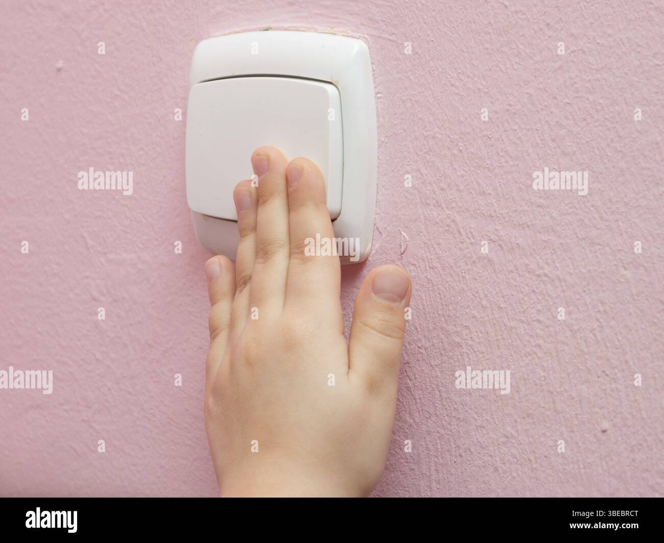 Hand des Kindes drückt den Lichtschalter, close-up Stockfoto