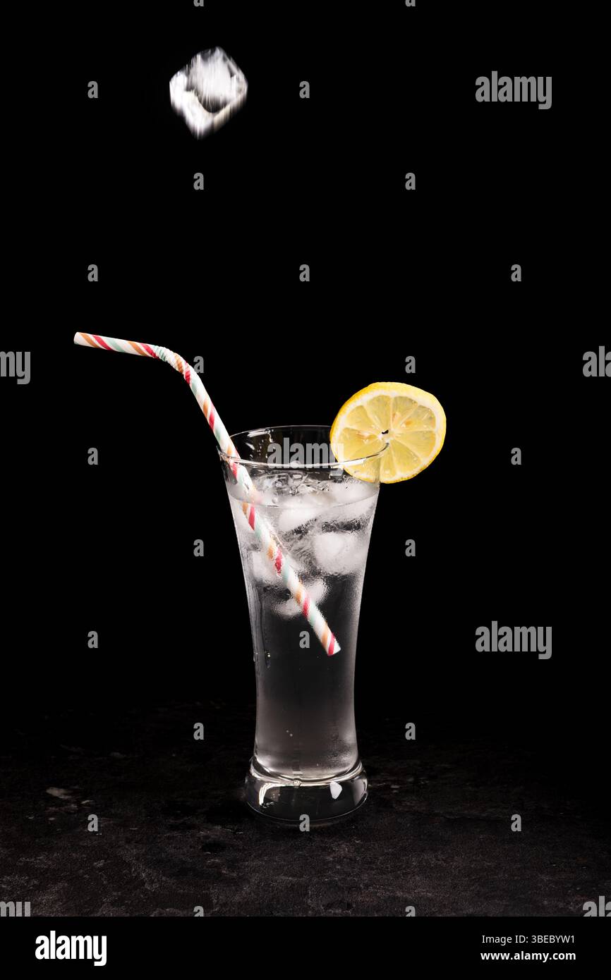 Ein Glas Limonade mit Strohhalm drin. Der Strohhalm befindet sich im Glas und der Zitronenkeil befindet sich oben auf dem Glas Stockfoto