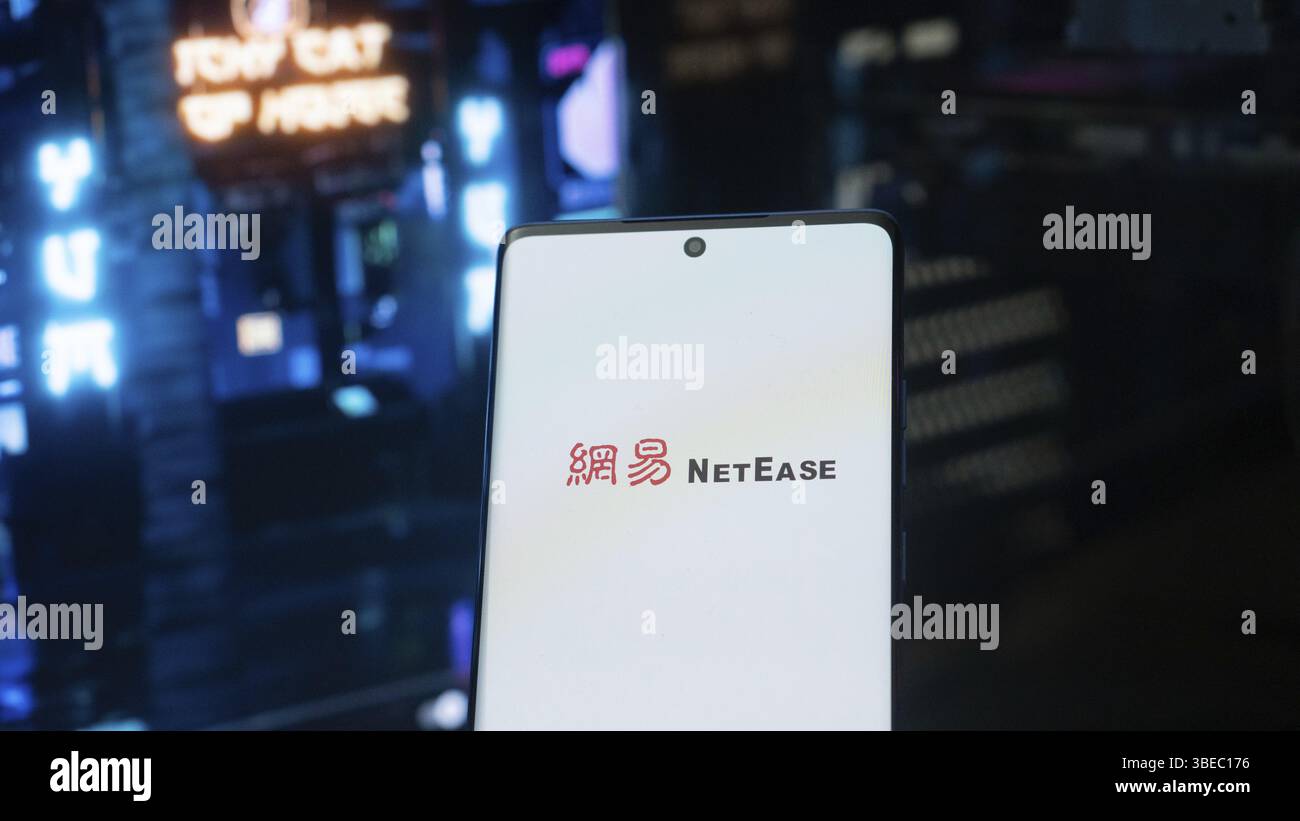Smartphone mit NetEase-Logo in futuristischer, neonbeleuchteter Umgebung Stockfoto
