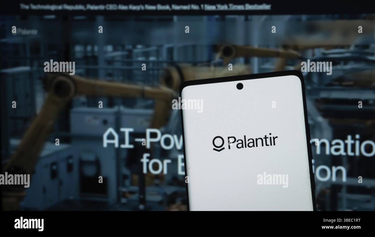 Smartphone mit Palantir-Logo vor Robotik und KI-Hintergrund Stockfoto