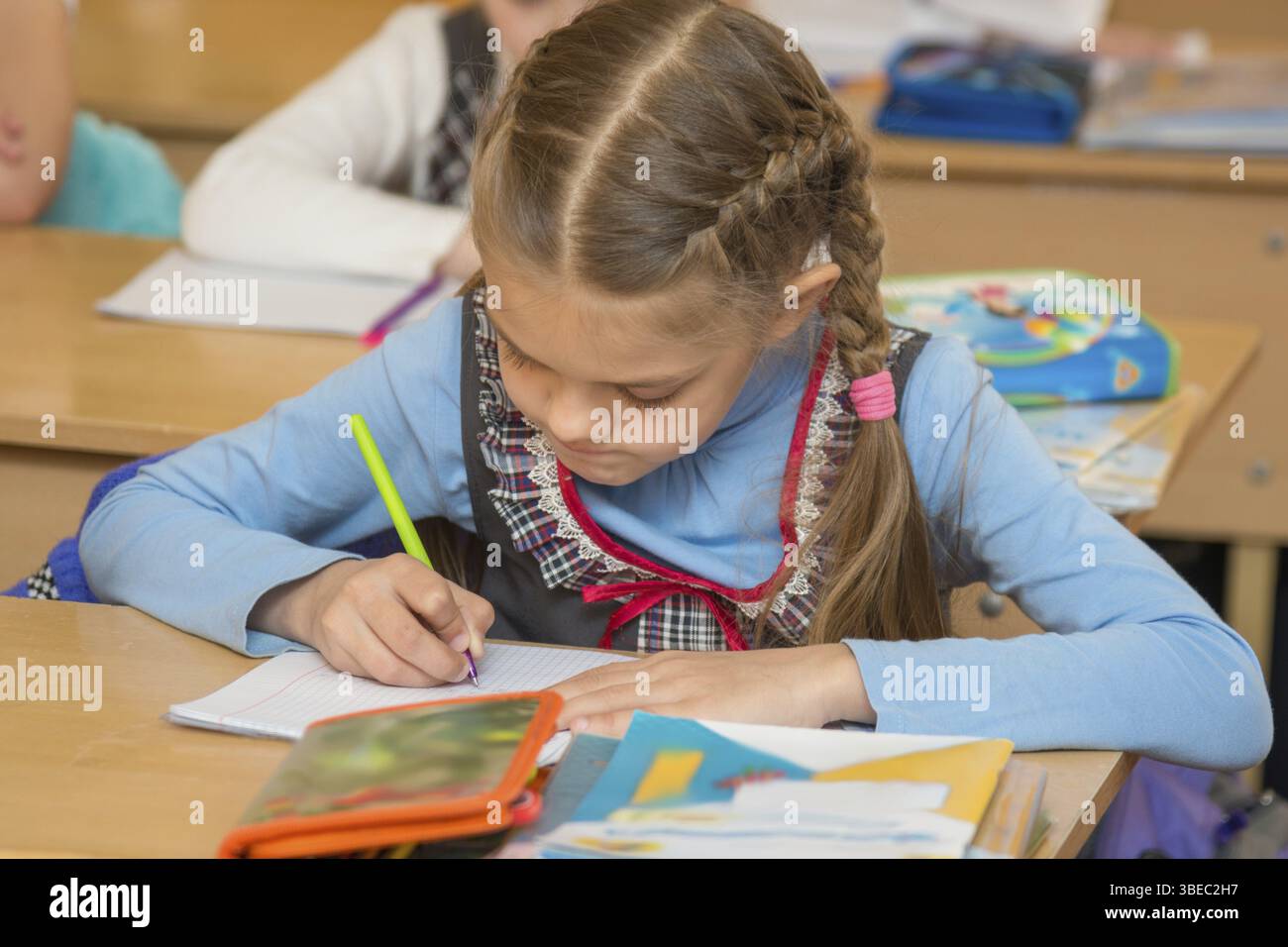 Erste-Grader an eine Lehre der Mathematik Beispiele Notebook lösen Stockfoto