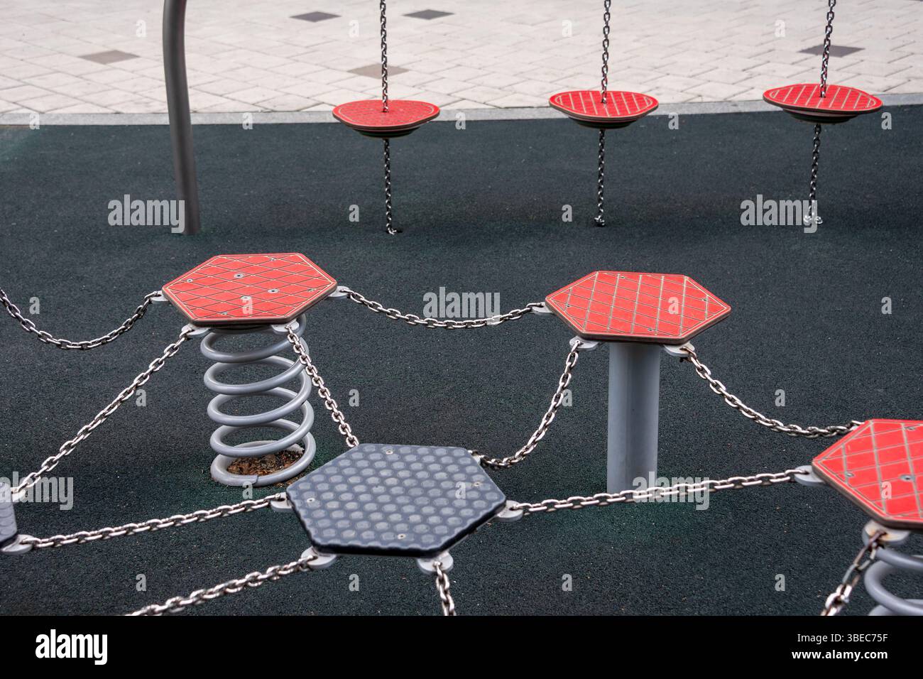 Moderner Spielplatz mit sechseckigen Plattformen, Federn und Ketten, für Kinder im Freien und Fitness. Die strapazierfähigen Materialien A Stockfoto