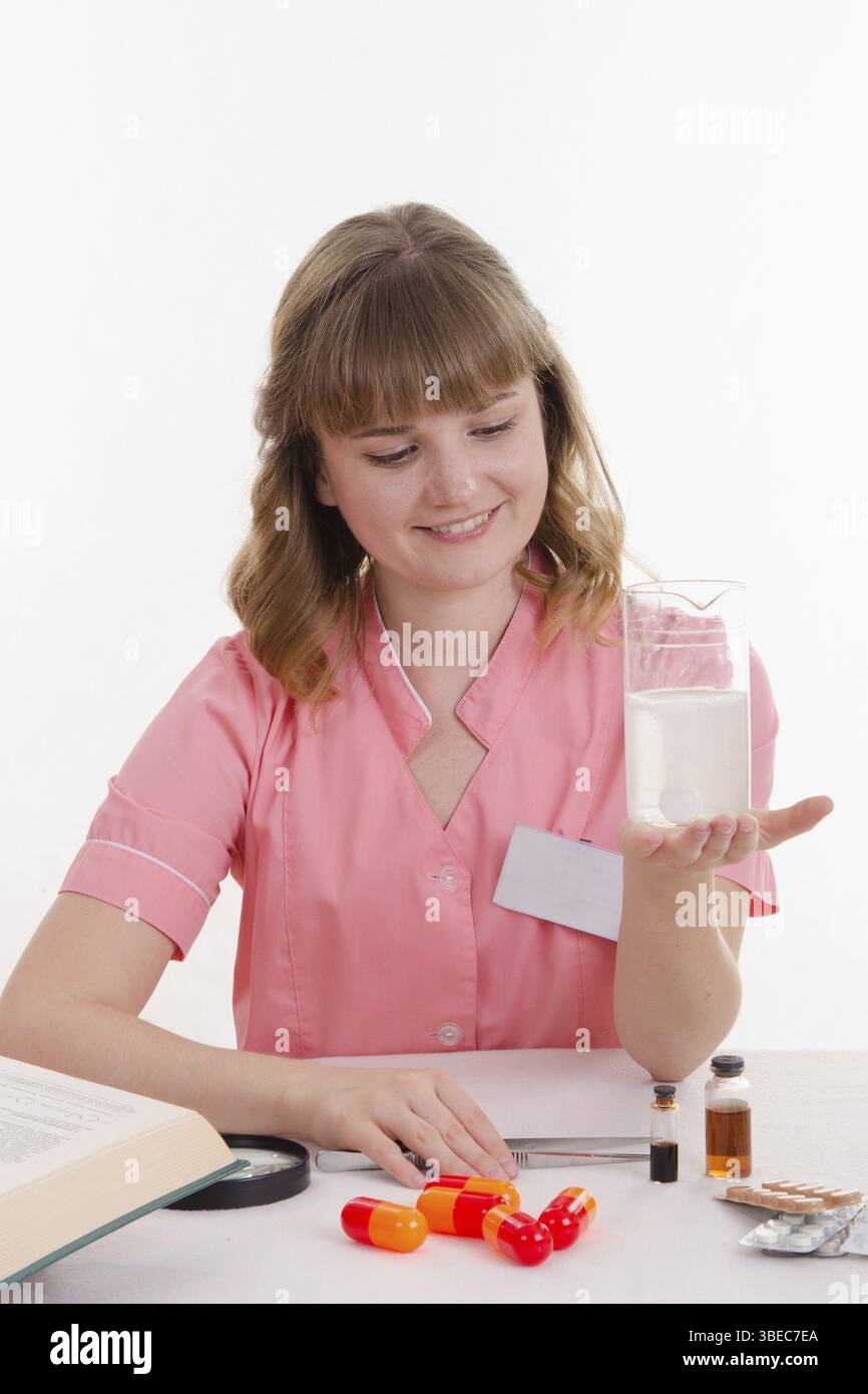 Apotheker am Tisch lesen ein dickes Handbuch Medikamente Stockfoto