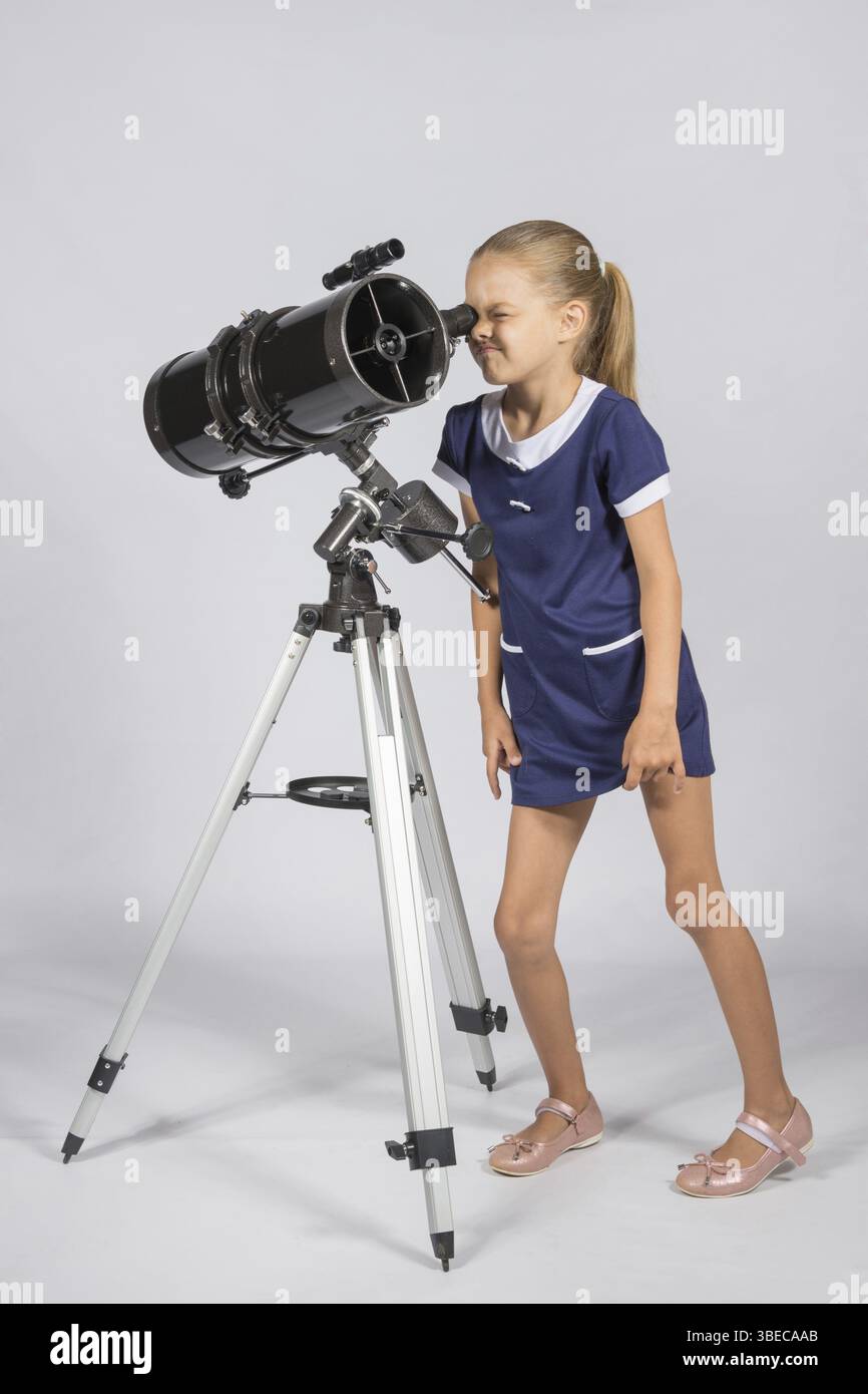 Junge lustige Astronom sieht durch das Okular des Teleskops Stockfoto