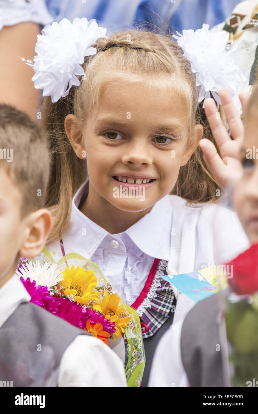 Erstklässler am 1. September, die Linie Gruß winken Freund Stockfoto
