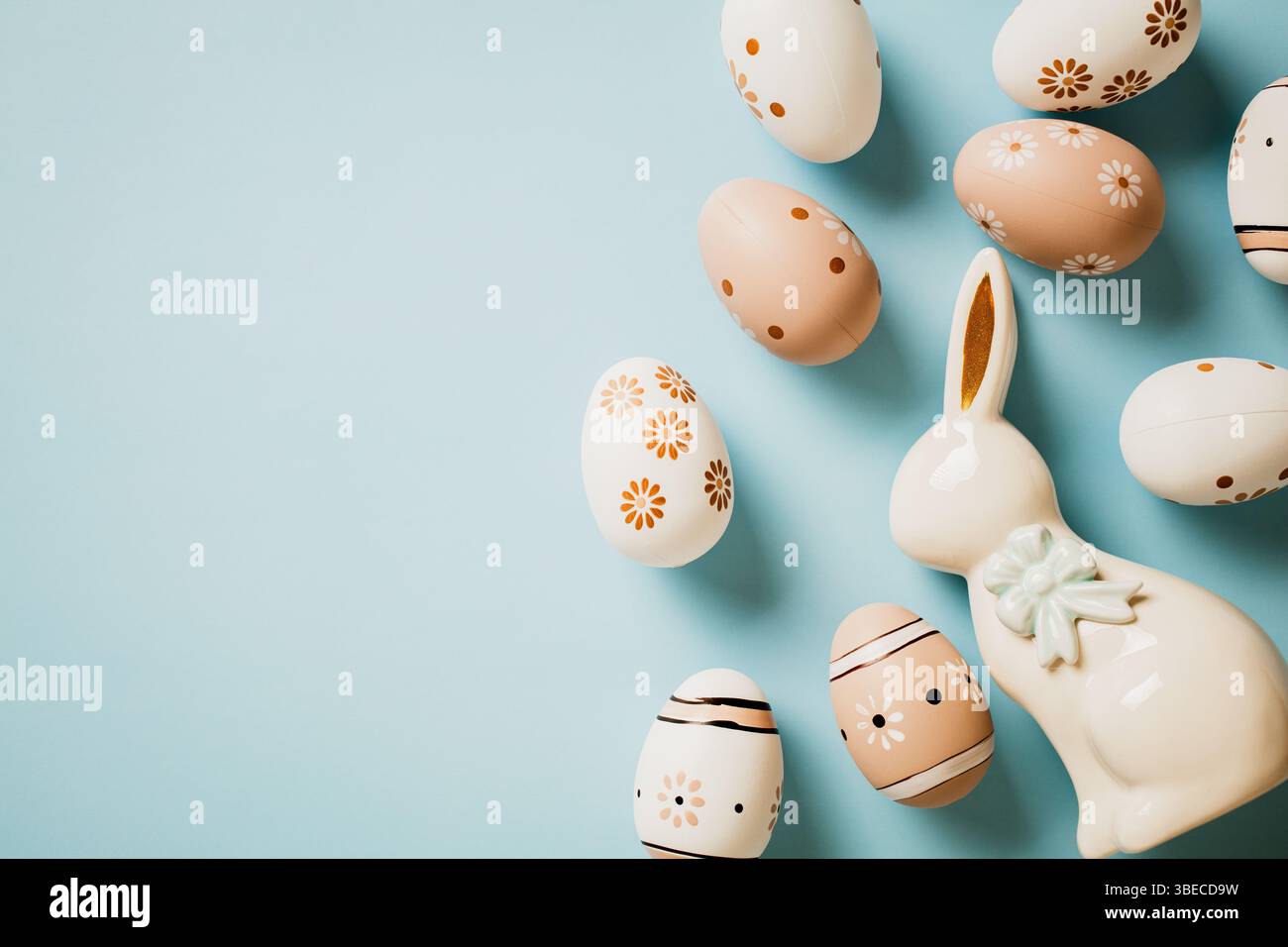 Happy Easter-Konzept. Schöne Blumengemalte Ostereier und Keramikhase auf pastellblauem Hintergrund. Stockfoto