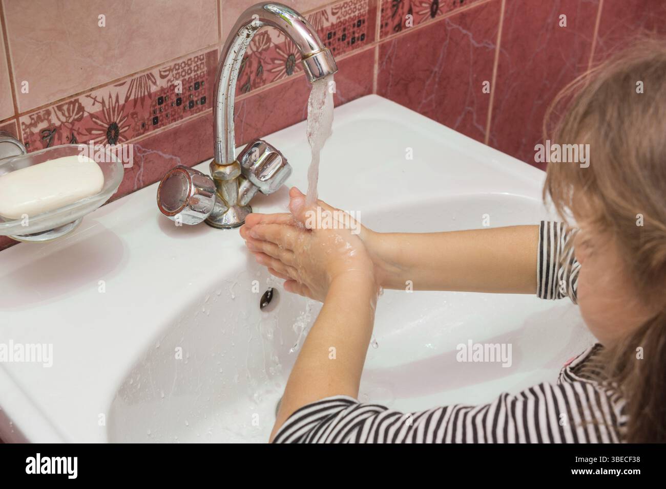 Fünfjähriges Mädchen waschen ihre Hände in der Spüle Stockfoto