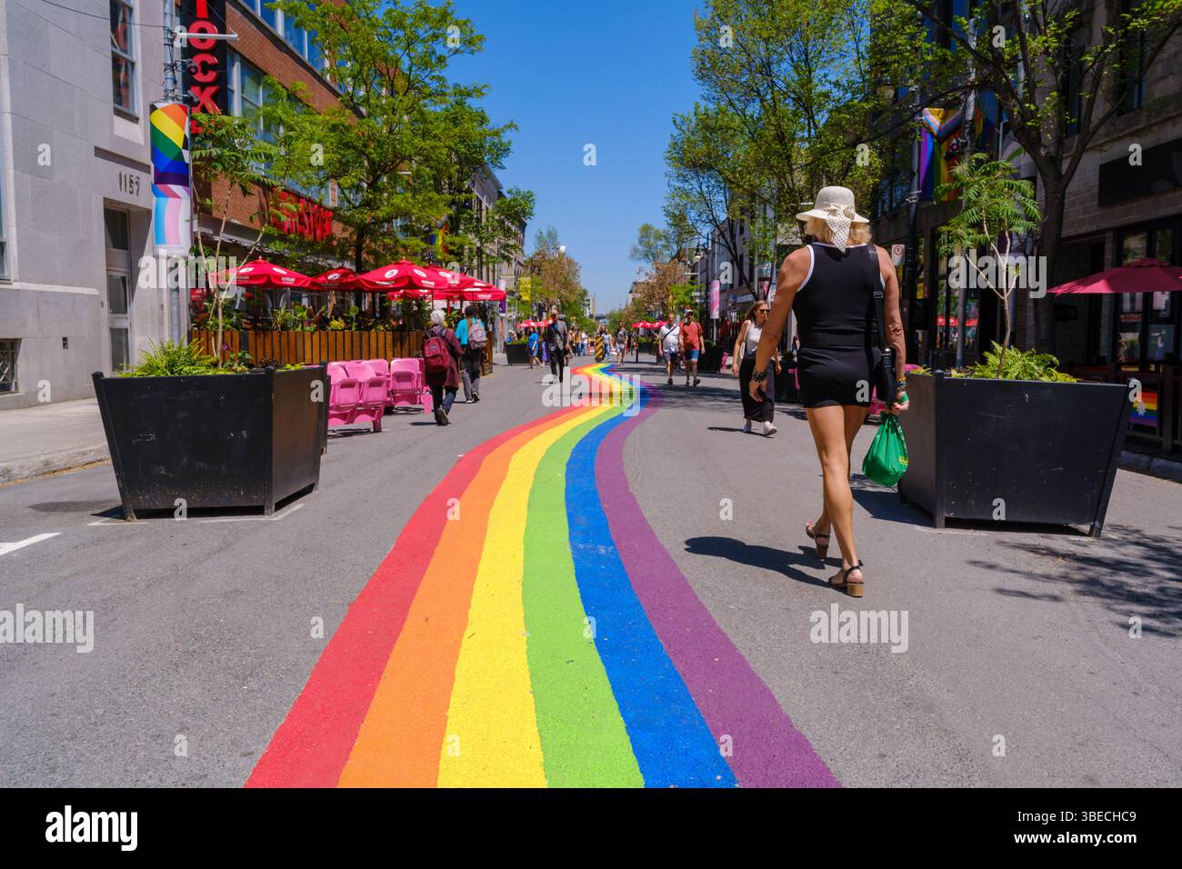 Montreal, Kanada – 28. Mai 2025: Die Menschen laufen entlang der Sainte-Catherine Street im Gay Village, wo sich die Regenbogenstraße durch das Nachbarland erstreckt Stockfoto