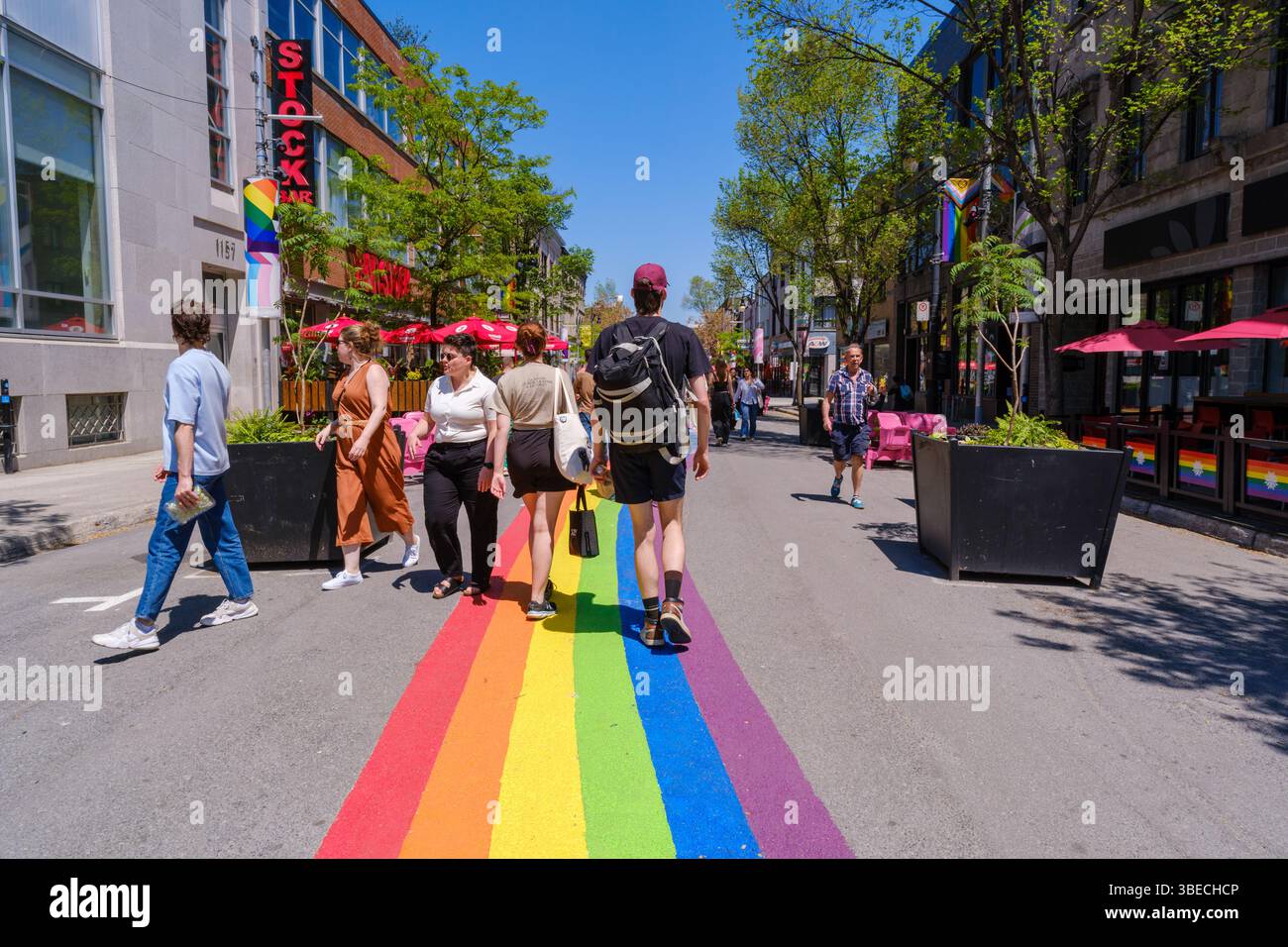 Montreal, Kanada – 28. Mai 2025: Die Menschen laufen entlang der Sainte-Catherine Street im Gay Village, wo sich die Regenbogenstraße durch das Nachbarland erstreckt Stockfoto