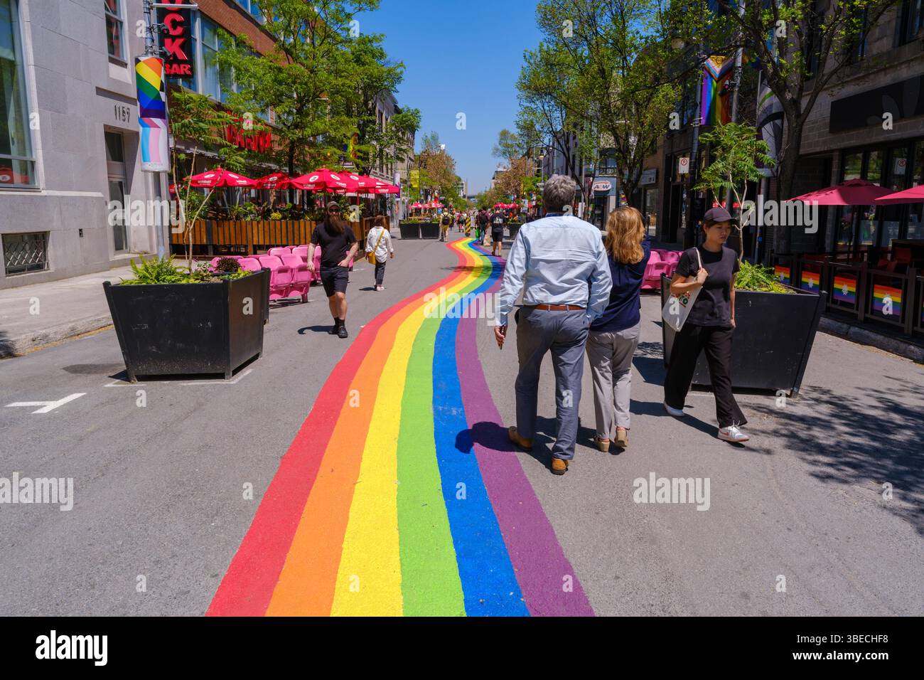 Montreal, Kanada – 28. Mai 2025: Die Menschen laufen entlang der Sainte-Catherine Street im Gay Village, wo sich die Regenbogenstraße durch das Nachbarland erstreckt Stockfoto