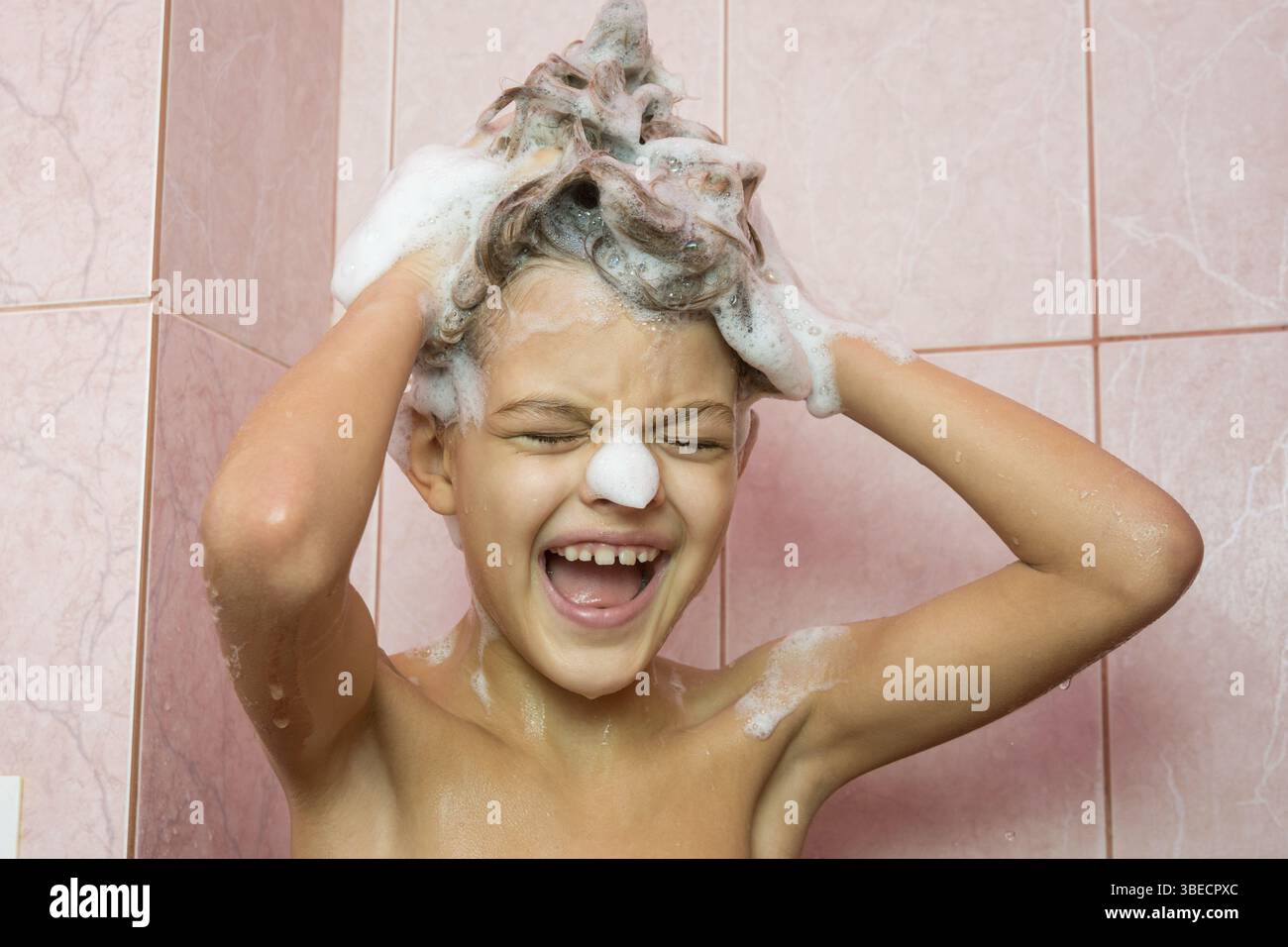 Lustiges Mädchen waschen Sie ihre Haare mit shampoo Stockfoto