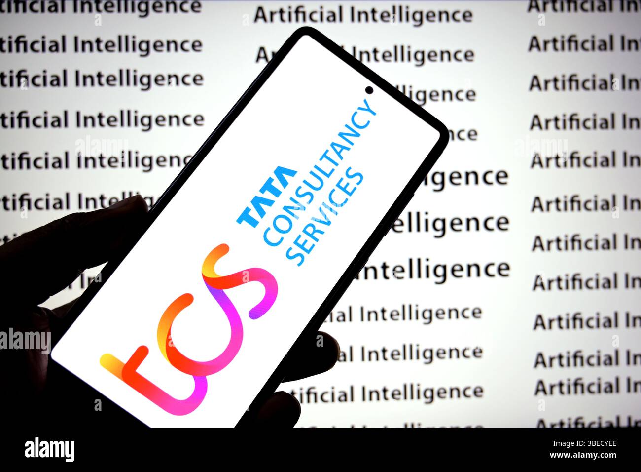 In dieser Abbildung ist ein TCS-Logo (Tata Consultancy Services) auf einem Smartphone mit einer Künstlichen Intelligenz (Inschriften) im Hintergrund zu sehen. Stockfoto