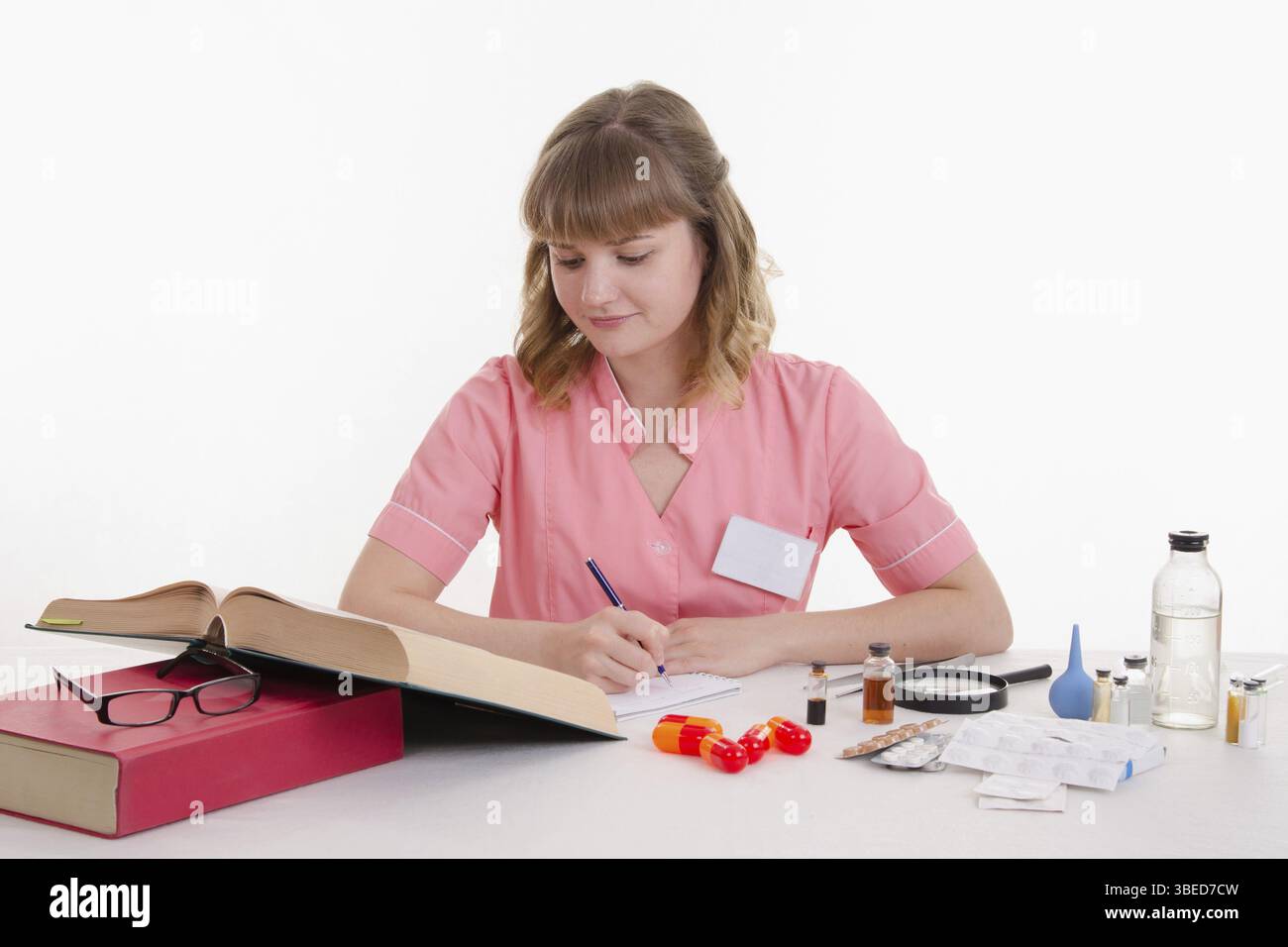 Apotheker am Tisch lesen ein dickes Handbuch Medikamente Stockfoto