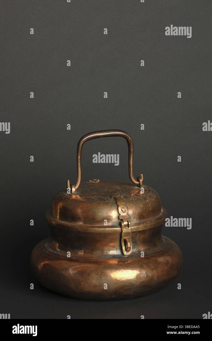 Alte Metallschale auf dunklem Hintergrund. Antikes Geschirr aus Bronze Stockfoto