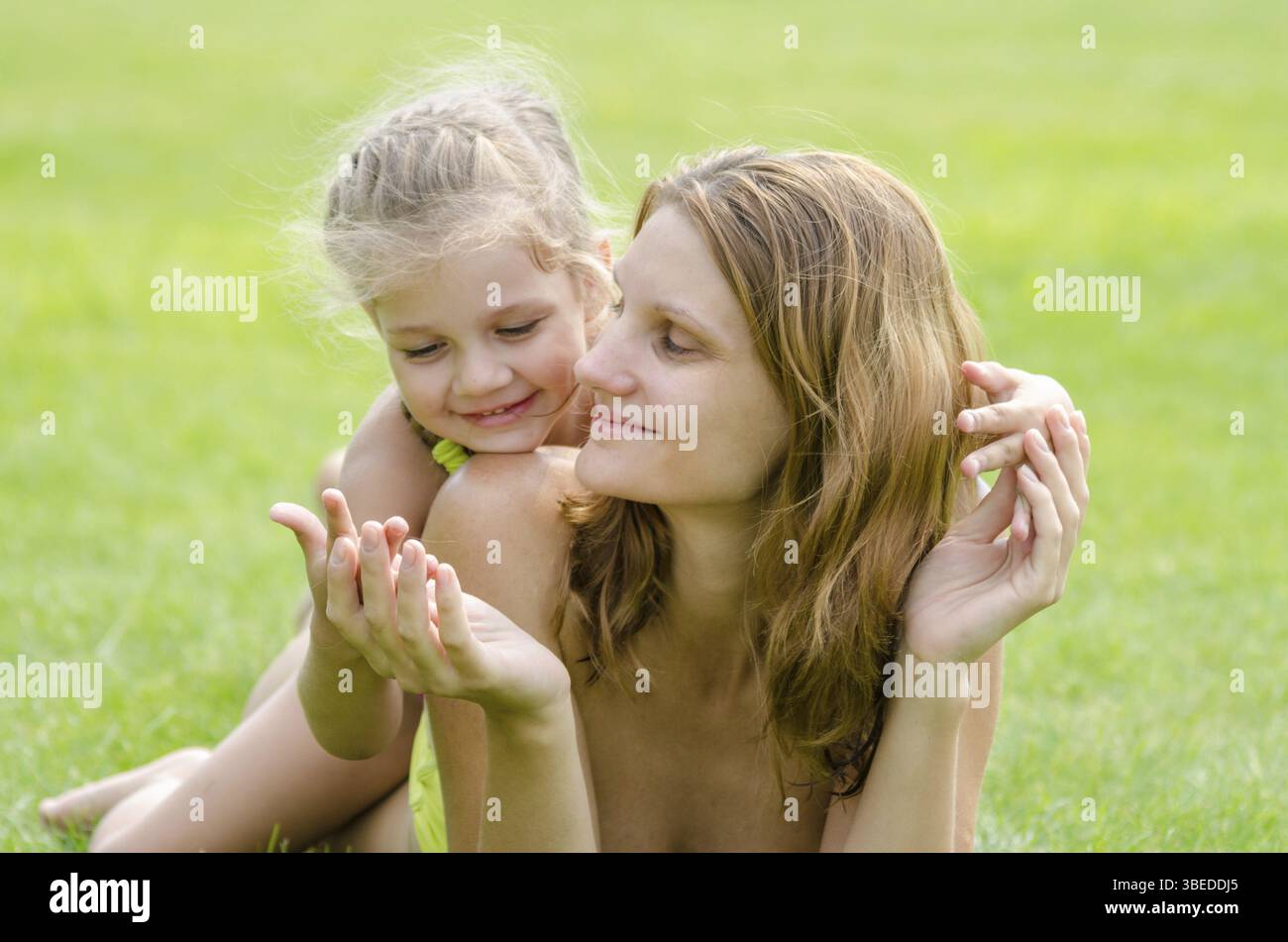 Mutter und Tochter Spaß umarmen die Sommer-Picknick auf einem grünen Rasen Stockfoto