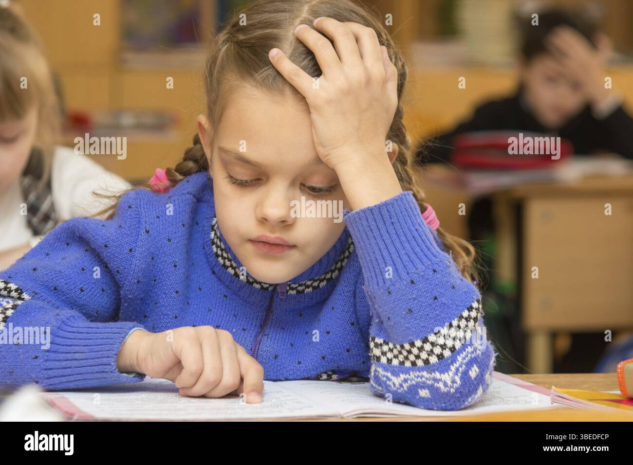 Erste-Grader an eine Lektion liest den Text, fährt man mit seinem Finger entlang der Linien Stockfoto