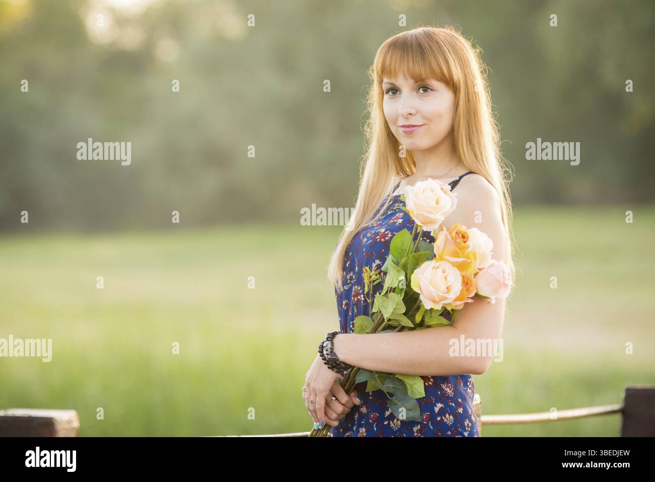 Schöne Mädchen auf einer Flussbrücke mit einem Blumenstrauß. Porträt Stockfoto