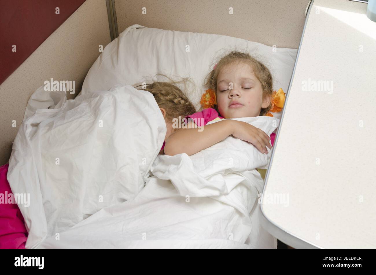 Zwei Kinder schlafen im Zug auf dem gleichen Boden Standort im Wagen zweiter Klasse Abteil Stockfoto