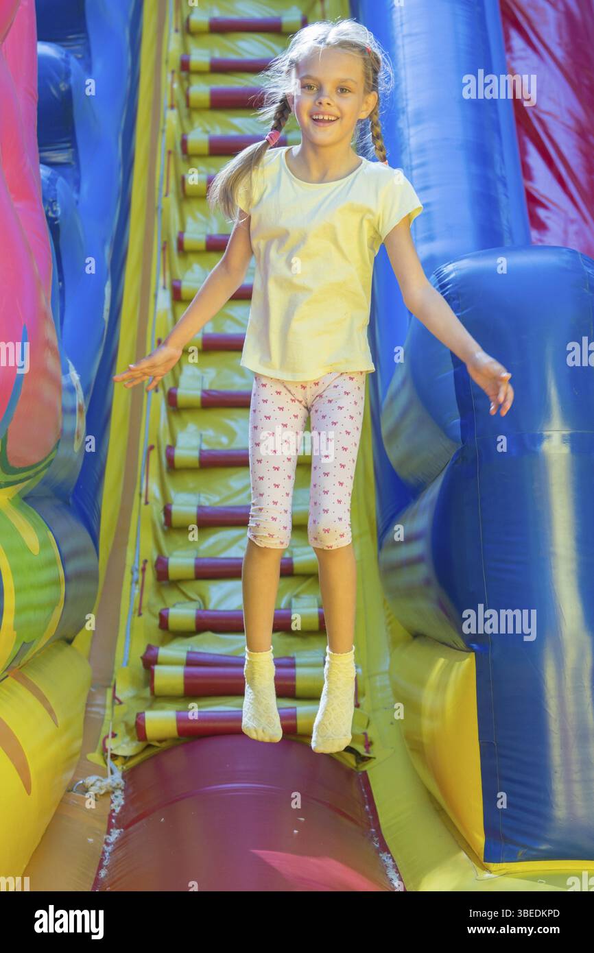 Glückliches Mädchen auf einem aufblasbaren Trampolin springen Stockfoto