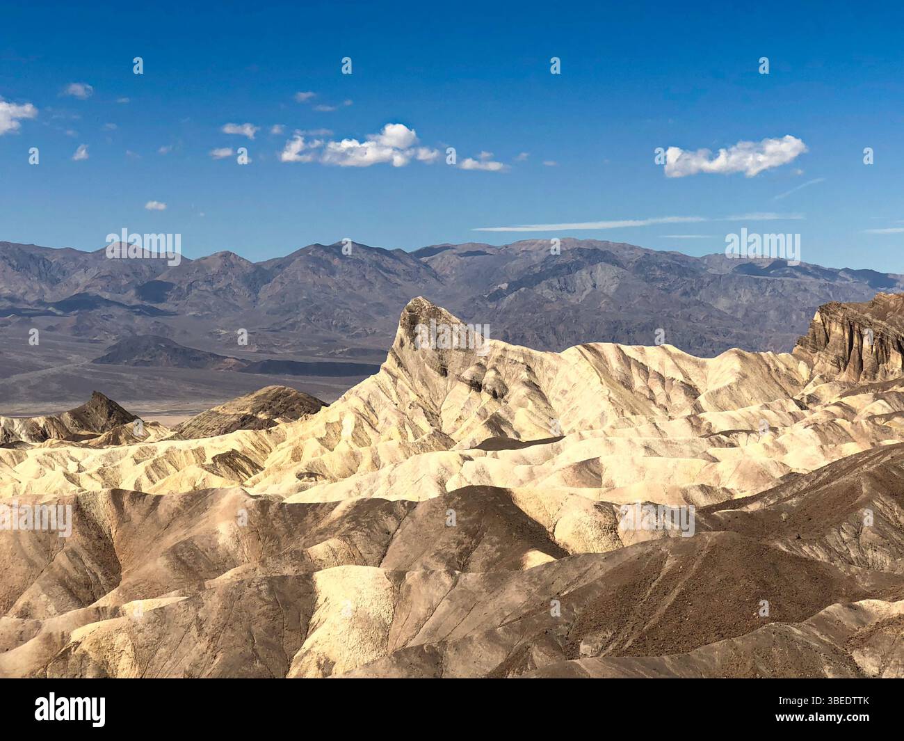 Sonnenaufgang über Zabriskie Point im Death Valley mit erodierten Badlands, farbenfrohen Graten und Wüstenlandschaft unter dramatischem Licht. - Smartphone-aufgenommenes Stockfoto