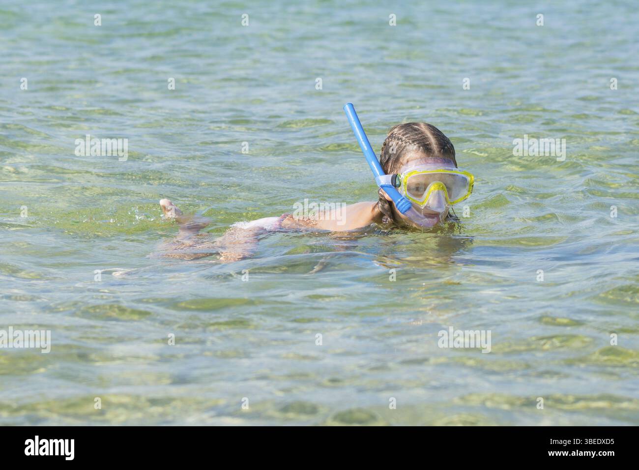 Sechsjährigen Mädchen schwimmt mit einer Maske und Schnorchel unter Wasser am Meer Stockfoto