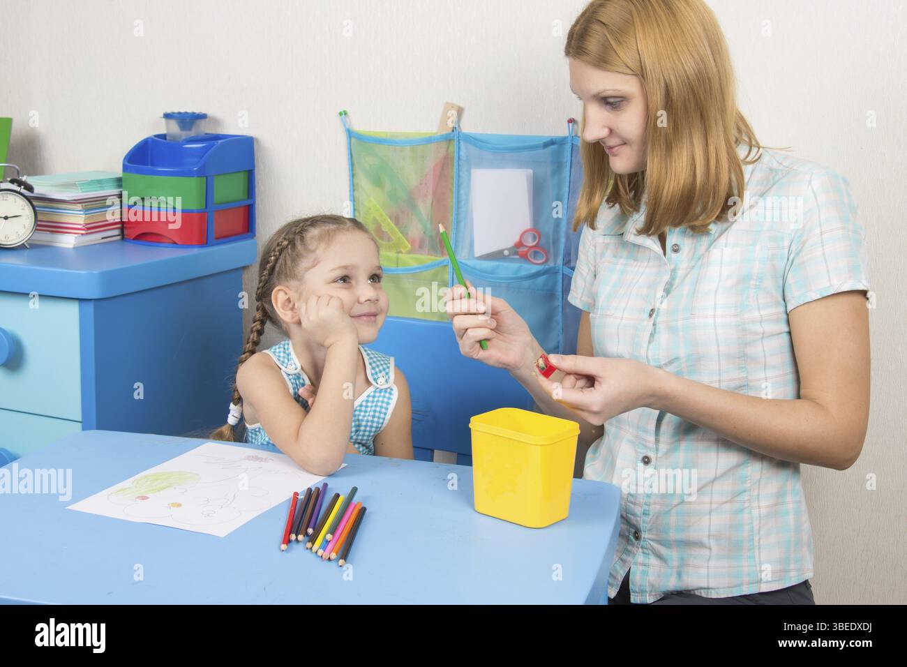 Eine fünfjähriges Mädchen engagiert sich Erwachsene junge schöne Mädchen sitzen am Tisch zu Hause Kinder Stockfoto
