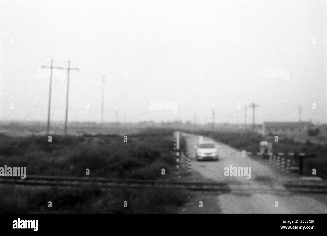 Ende der 2000er Jahre Landstraße China Level Crossing mit herannahendem Auto Stockfoto