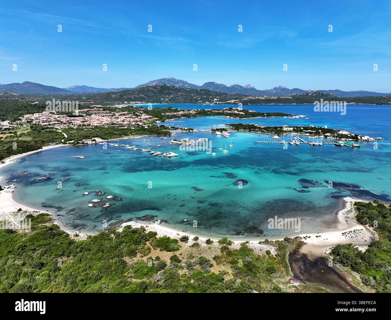 Blick aus der Vogelperspektive auf Marinella Strand und Hafen, weißer Sandstrand, der von einem wunderschönen türkisfarbenen Wasser getaucht ist. Marinella Beach, Porto Rotondo, Costa Smeralda, Stockfoto