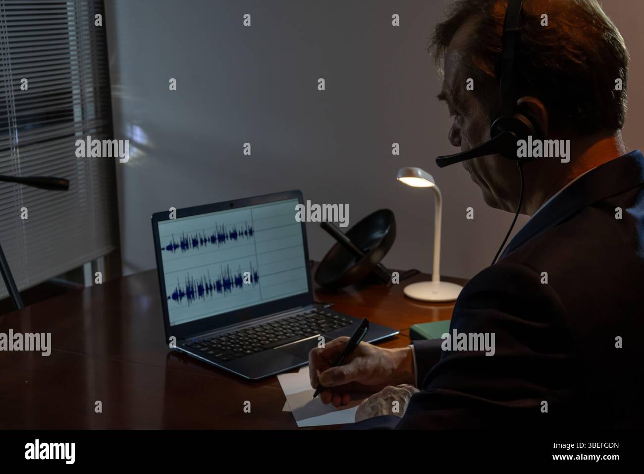 Nachtüberwachung: Ein Privatdetektiv führt mit Hilfe von Technologie Film- und Audioaufnahmen durch Stockfoto