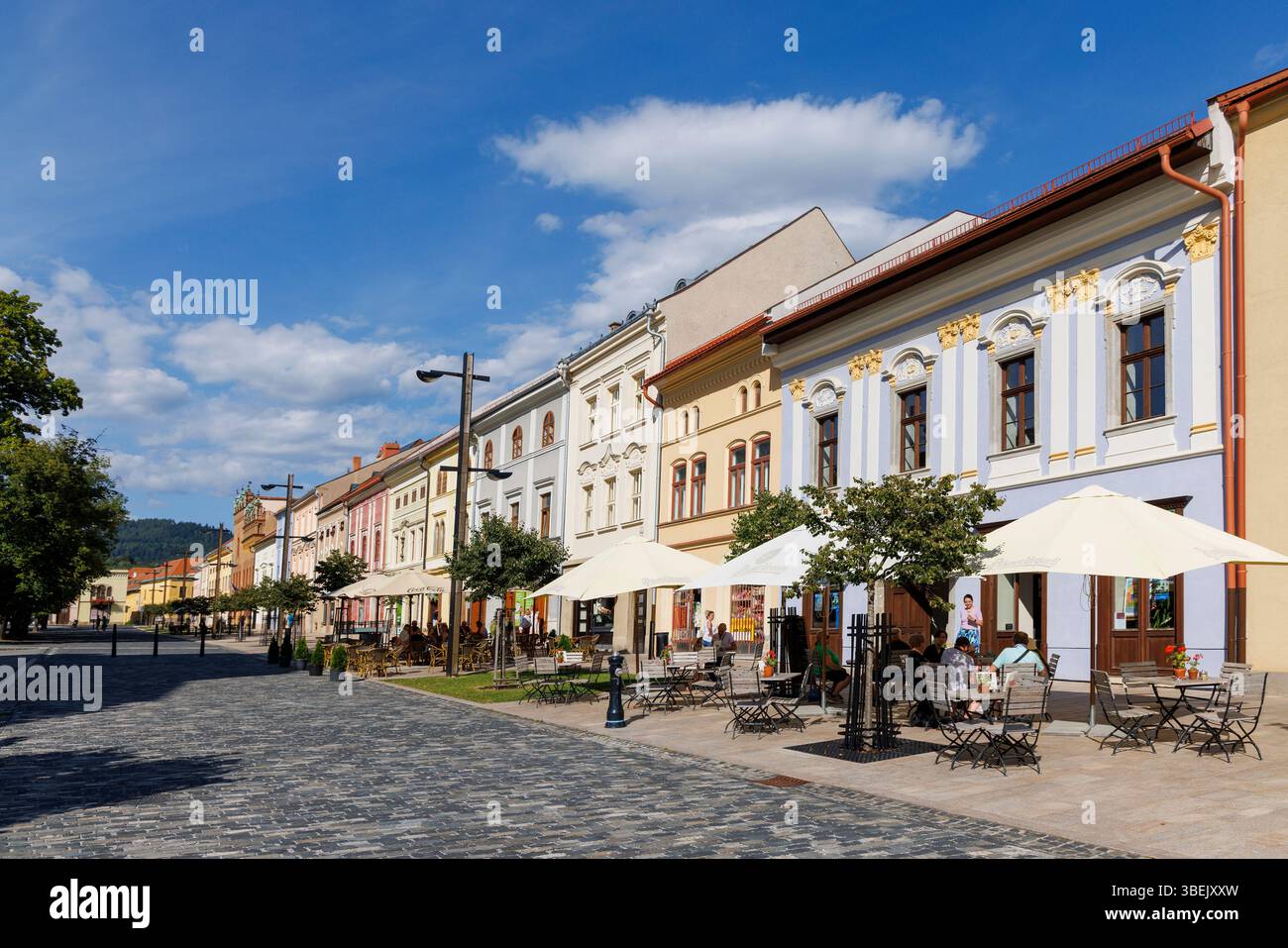 Menschen, die im Schatten von Regenschirmen sitzen in Levoca, Slowakei Stockfoto