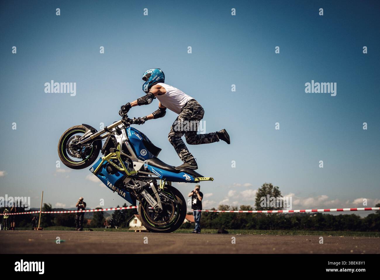 Motorrad-Stuntfahrer, der einen Wheelie-Trick auf Yamaha-Motorrad macht Stockfoto