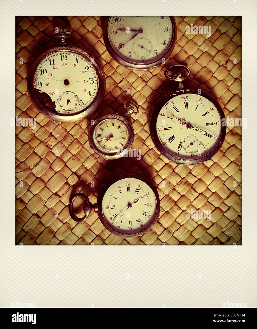 Verschiedene Vintage-Stoppuhren sind eng auf einer gewebten Oberfläche zu sehen, was ihre unterschiedlichen Designs unterstreicht Stockfoto