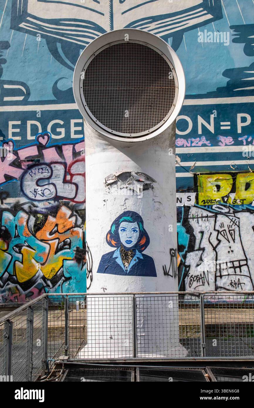 Pariser Streetart: Wheatpaste-Ausschnittplakat von FKDL (Frank Duval) auf dem Windlaufventilator am Place Igor Strawinsky im Marais-Viertel von Paris, Frankreich. Stockfoto
