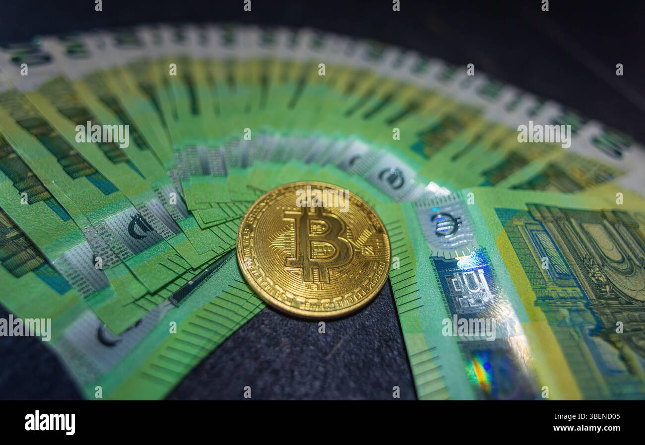 Goldene Bitcoin-Kryptowährungsmünze auf 100-Euro-Scheinen. Goldene Bitcoin-Kryptowährungsmünze auf 100-Euro-Scheinen. Bitcoin-Münzen und Bargeld-Hintergrund. *** Los Stockfoto