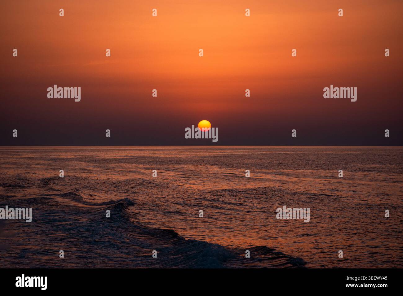 Goldener Sonnenuntergang über Tropea, Kalabrien, mit der Sonne reflektiert auf dem ruhigen Tyrrhenischen Meer und schafft eine magische und friedliche Küstenatmosphäre Stockfoto