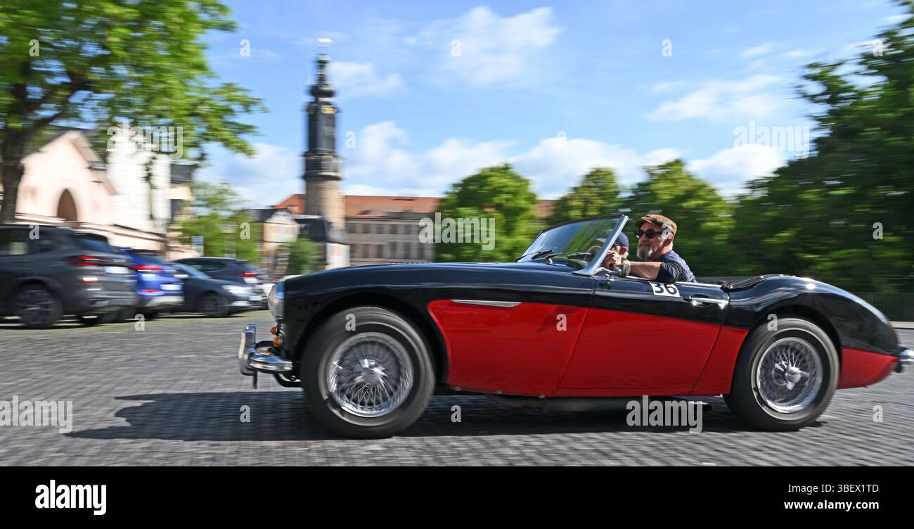Weimar, Deutschland. 30. Mai 2025. Hans-Jürgen Schick und Michael Kring starten die erste Etappe der ADAC Oldtimer Tour Thüringen in einem Austin-Healey 100/6 auf dem Platz der Demokratie in Weimars Innenstadt neben dem Residenzschloss und der Herzogin Anna Amalia Bibliothek. Fast 90 Fahrzeuge sind auf zwei Etappen in Thüringen unterwegs. Quelle: Martin Schutt/dpa/Alamy Live News Stockfoto