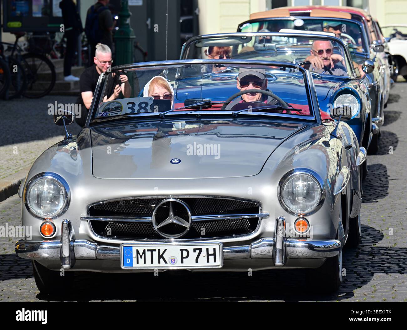 Weimar, Deutschland. 30. Mai 2025. Gerda und Peter Flohr starten die erste Etappe der ADAC Oldtimer Tour Thüringen in einem Mercedes-Benz 190 SL auf dem Platz der Demokratie in der Weimarer Innenstadt neben dem Residenzschloss und der Herzogin Anna Amalia Bibliothek. Fast 90 Fahrzeuge sind auf zwei Etappen in Thüringen unterwegs. Quelle: Martin Schutt/dpa/Alamy Live News Stockfoto