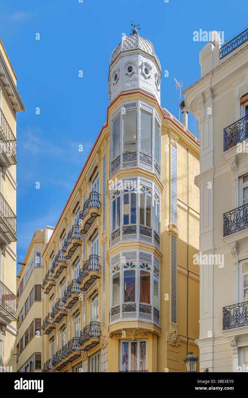 Atemberaubendes Eckgebäude Mit Verziertem Turm Und Balkonen In Valencia City. Historische Architektur, spanische Stadtszene, komplizierte Details, blauer Himmel, V Stockfoto