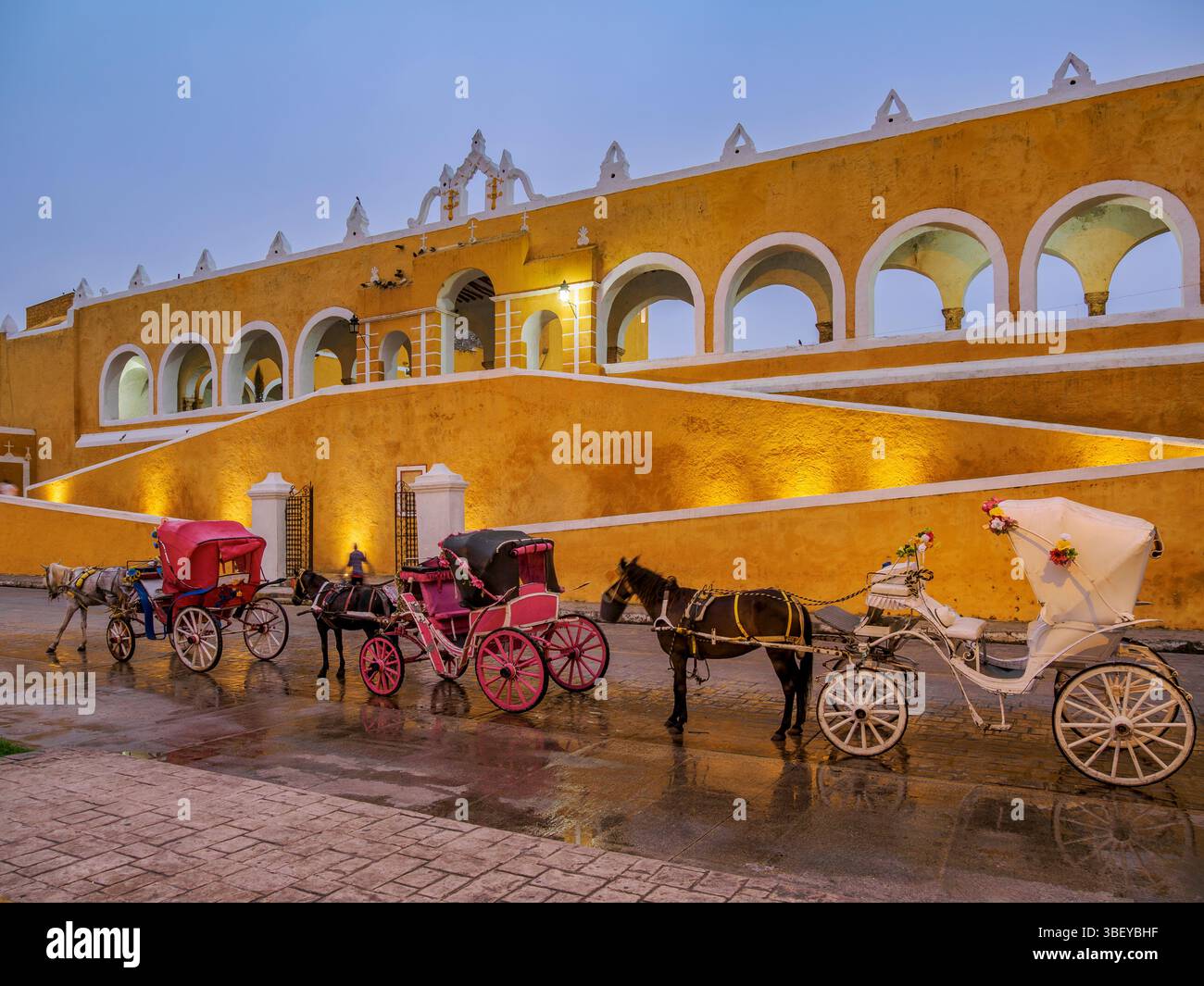 Pferdekutschen vor dem Kloster San Antonio de Padua bei Sonnenaufgang, Izamal, Bundesstaat Yucatan, Mexiko Stockfoto