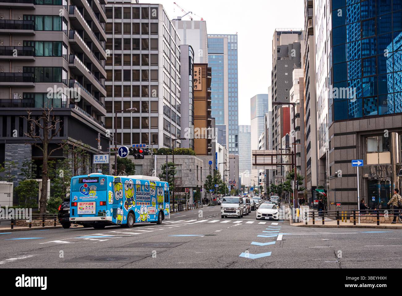 Straßen von Osaka, Japan. Ein blauer Bus inmitten eines Wolkenkratzers in der Gegend von Nakanoshima. Stockfoto