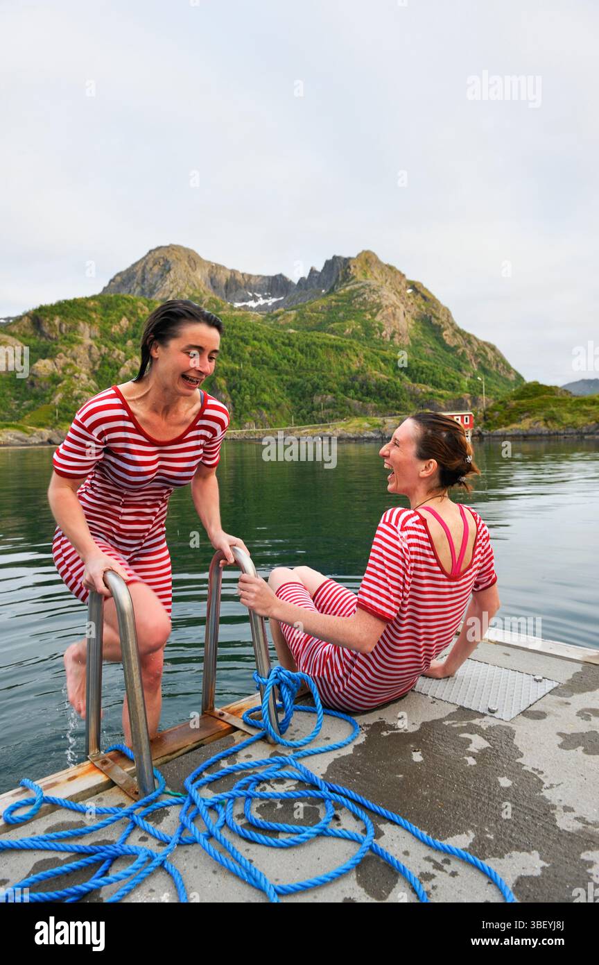 Junge Frauen, die im eisigen Fjord baden, Hamn i Senja Hotel, Senja Insel, Grafschaft Troms, Norwegen Stockfoto