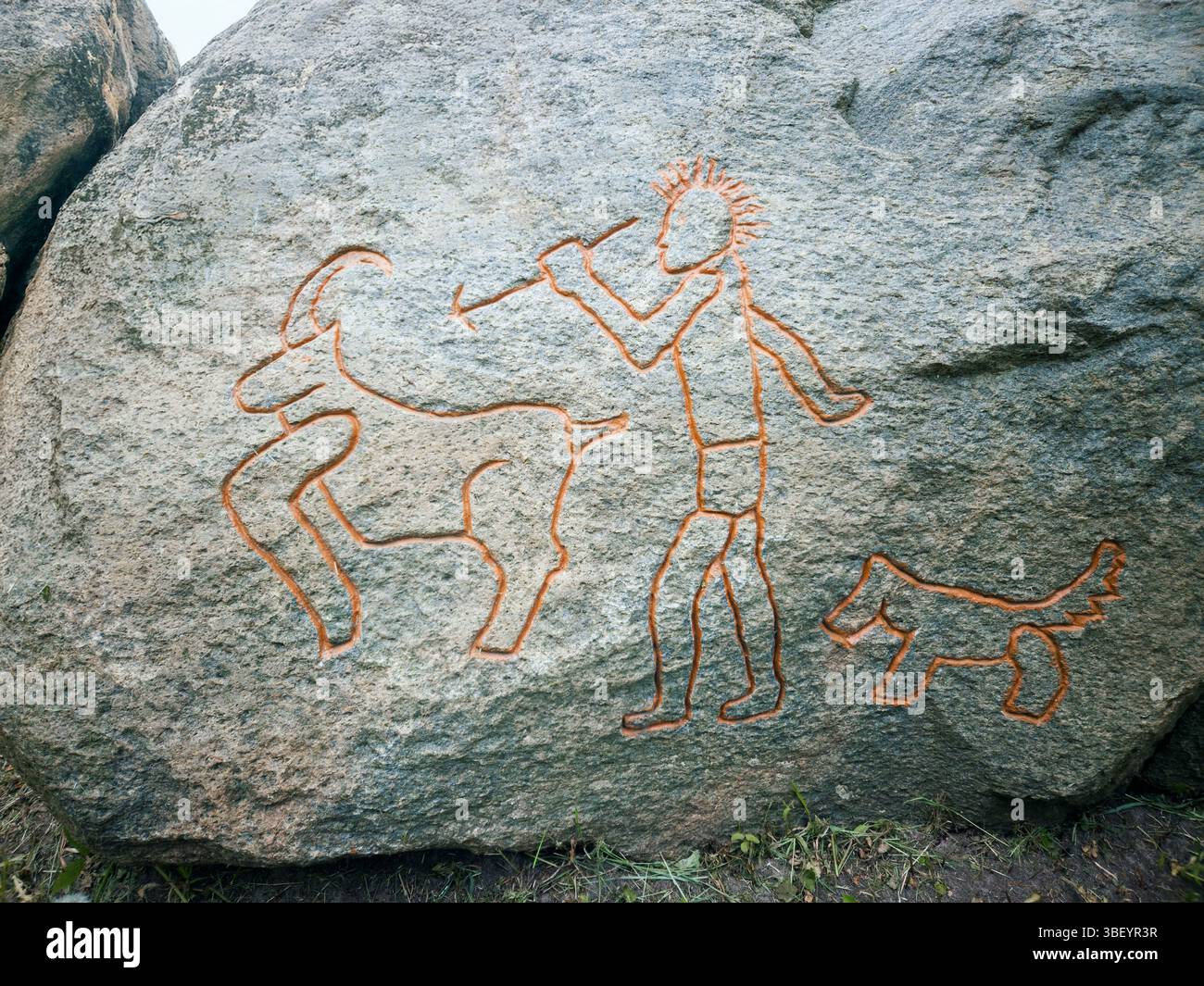 Prähistorisches Felsschnitzen einer Jagdszene Stockfoto