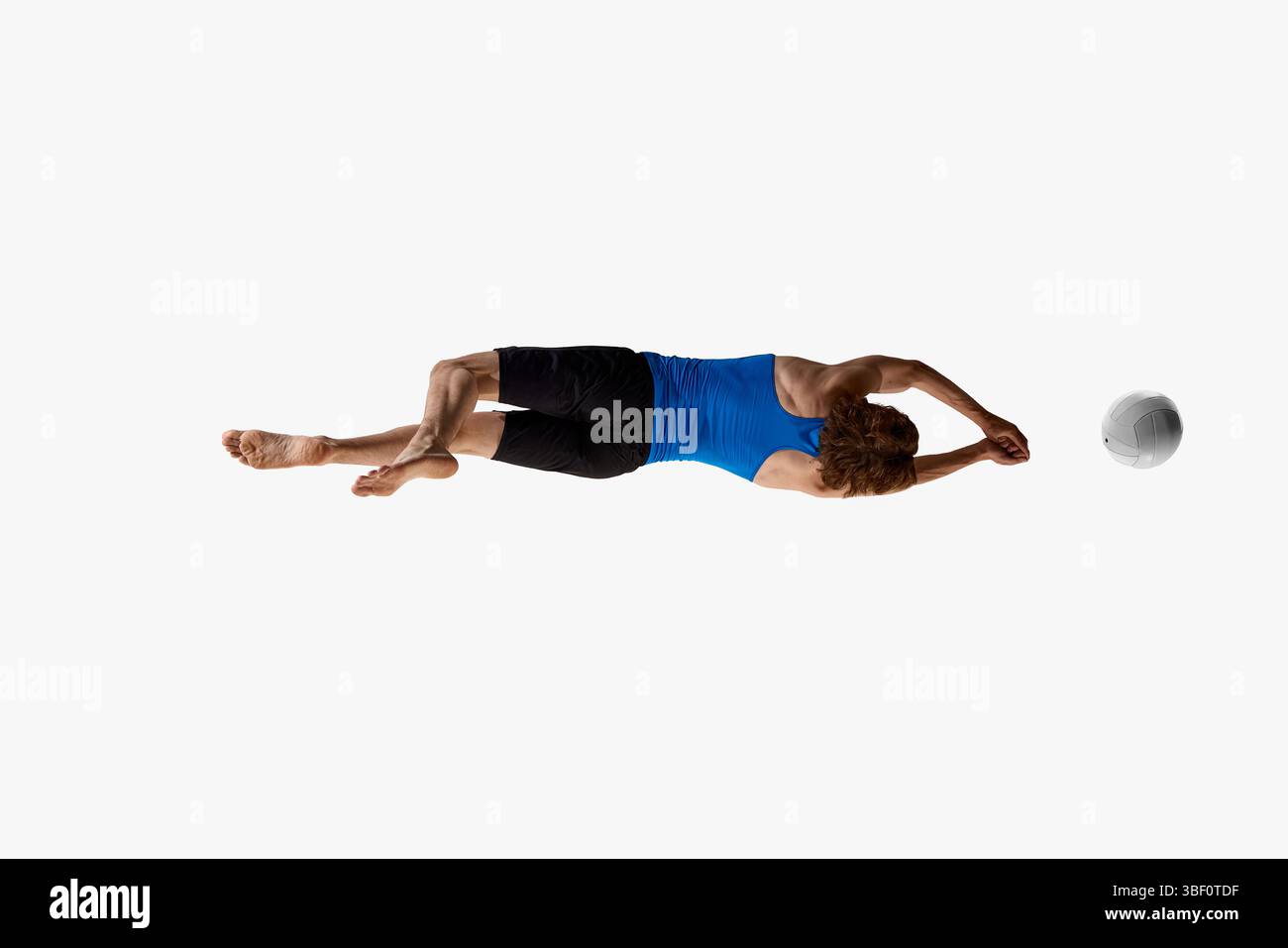 Rückansicht Foto eines männlichen Athleten, der seinen Körper im vollen Tauchgang dreht, während er Volleyball jagt, um vor weißem Studiohintergrund ein Tor zu erzielen Stockfoto